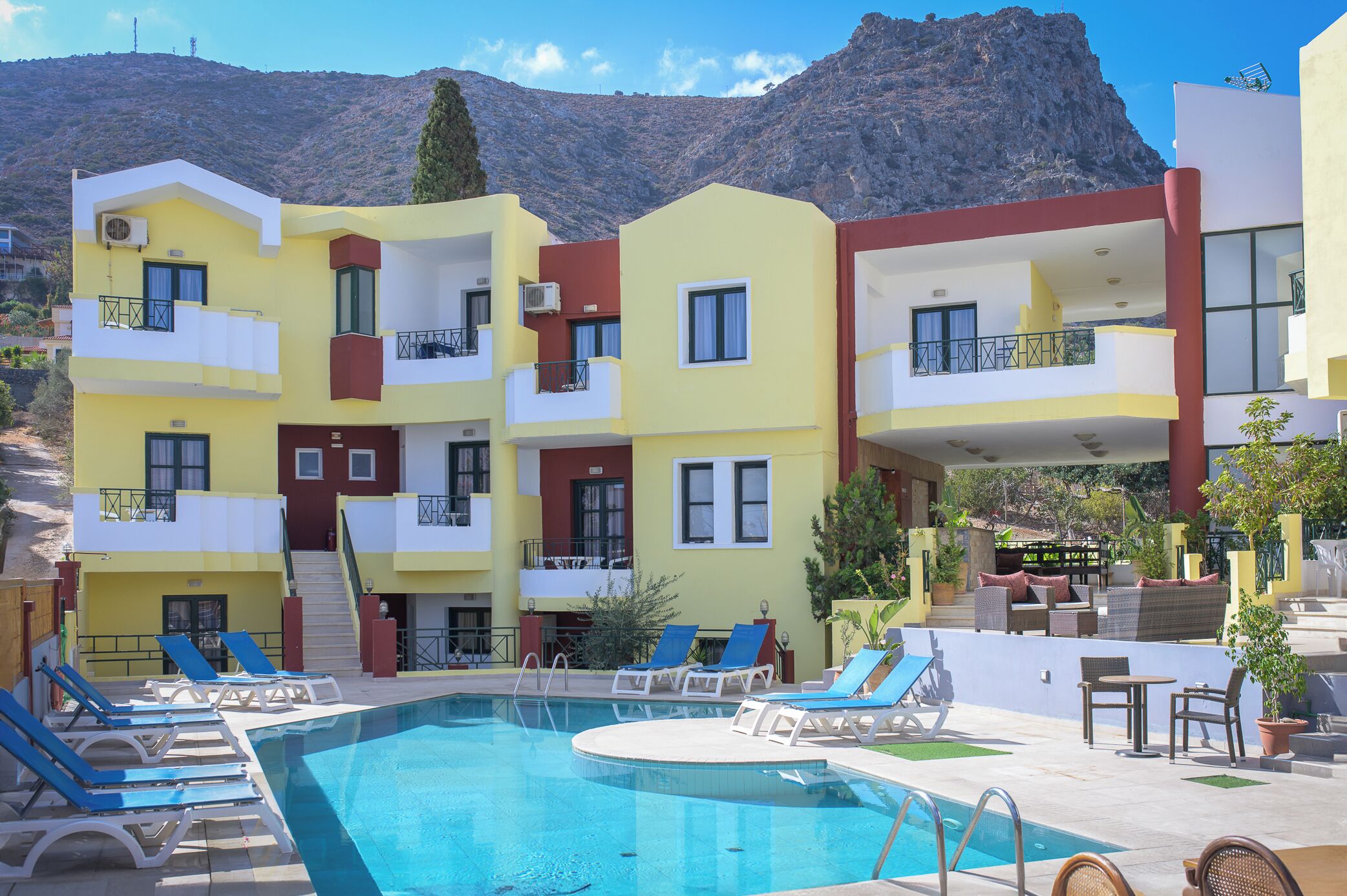 Un hôtel doté d’une piscine, de nombreux balcons et offrant une vue sur un paysage montagneux.