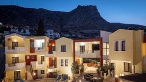 Un hôtel moderne à plusieurs étages, doté de balcons, d’un espace piscine et offrant une vue sur les montagnes.