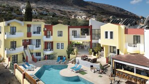 Un hôtel doté d’une piscine, d’un espace extérieur aménagé et offrant une vue sur les collines environnantes.