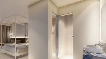 A modern hotel room with a four-poster bed, a bedside table, a wall-mounted light, and a bathroom with a sink and mirror.