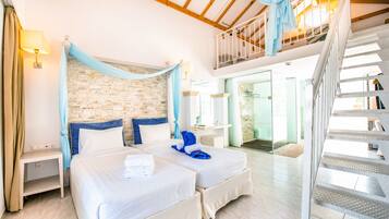 A hotel room with two beds, a stone wall, a balcony, and a staircase.