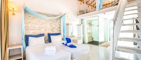 Habitación de hotel con dos camas, una pared de piedra, un balcón y una escalera.