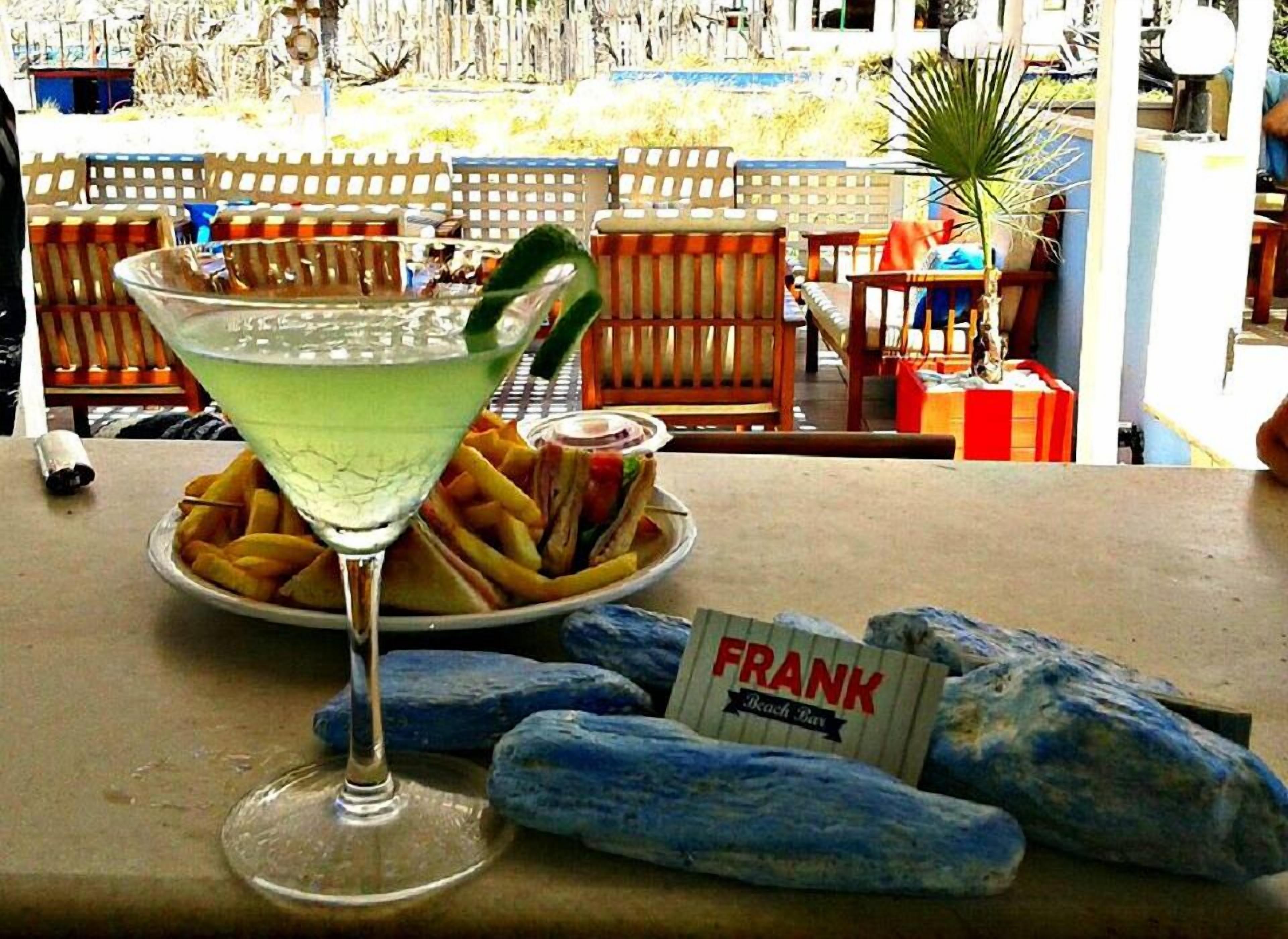 Et bord med et martini glas, pommes frites og et skilt med teksten 