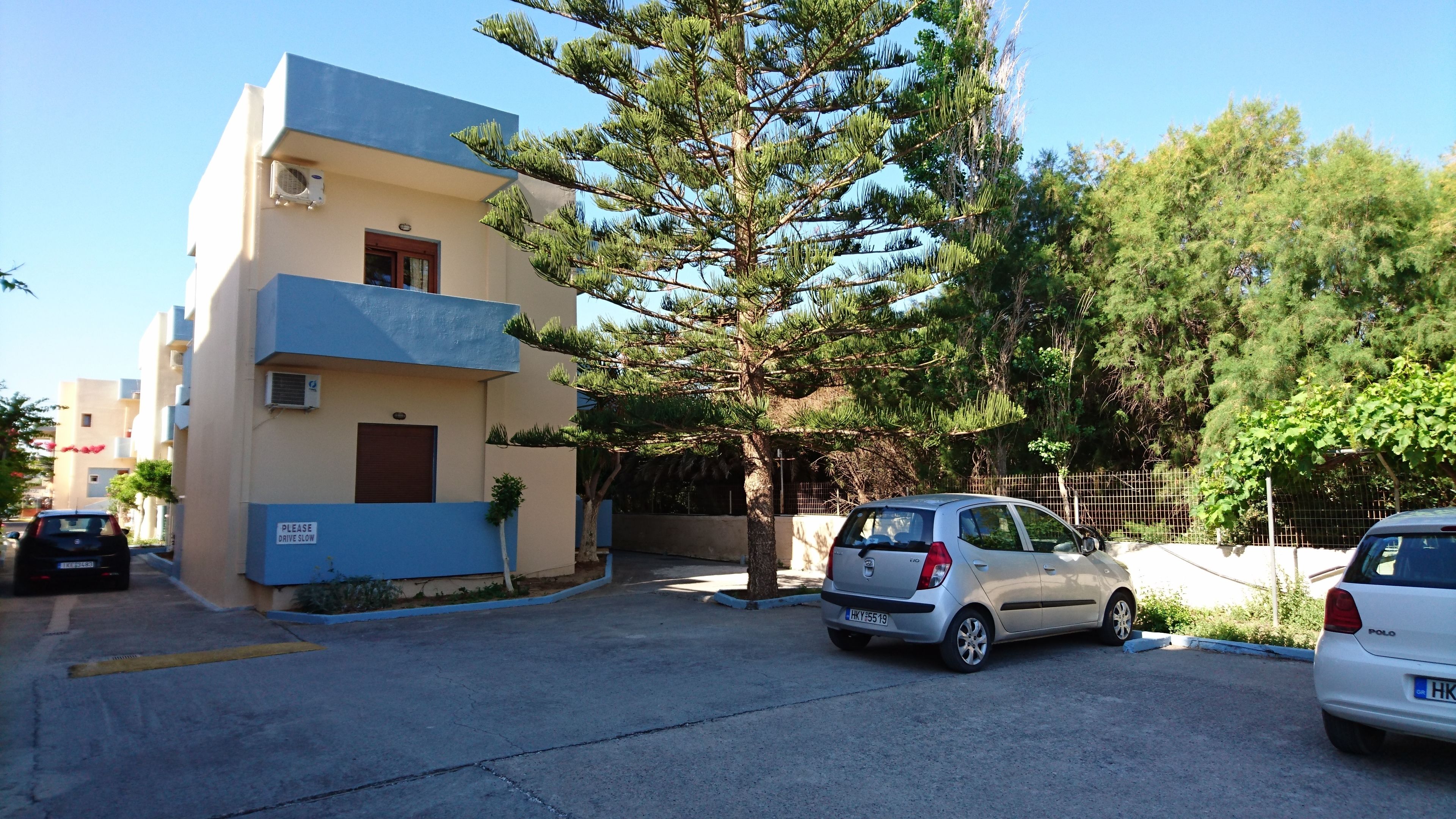 A two-story building with a blue exterior and a tree in front.