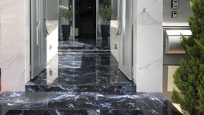 A modern hotel entrance with a marble staircase leading to a dark interior. - Rethymno Hills Apartments (Rethymno)