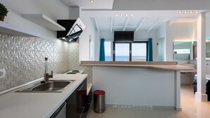 A modern kitchen with a central island, built-in appliances, and a view to the outside. - Rethymno Hills Apartments (Rethymno)