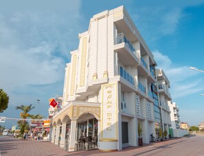 A multi-story hotel with a white facade and balconies. - Kadriye Sarp Otel (Serik)