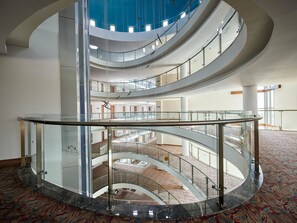 Ein mehrgeschossiges Atrium mit Glasgeländern und einem offenen zentralen Bereich.