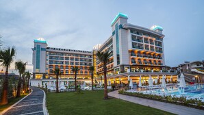 A hotel with multiple floors, outdoor pool, and palm trees.