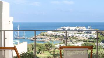 A balcony with a view of a coastal town, including a marina and buildings.