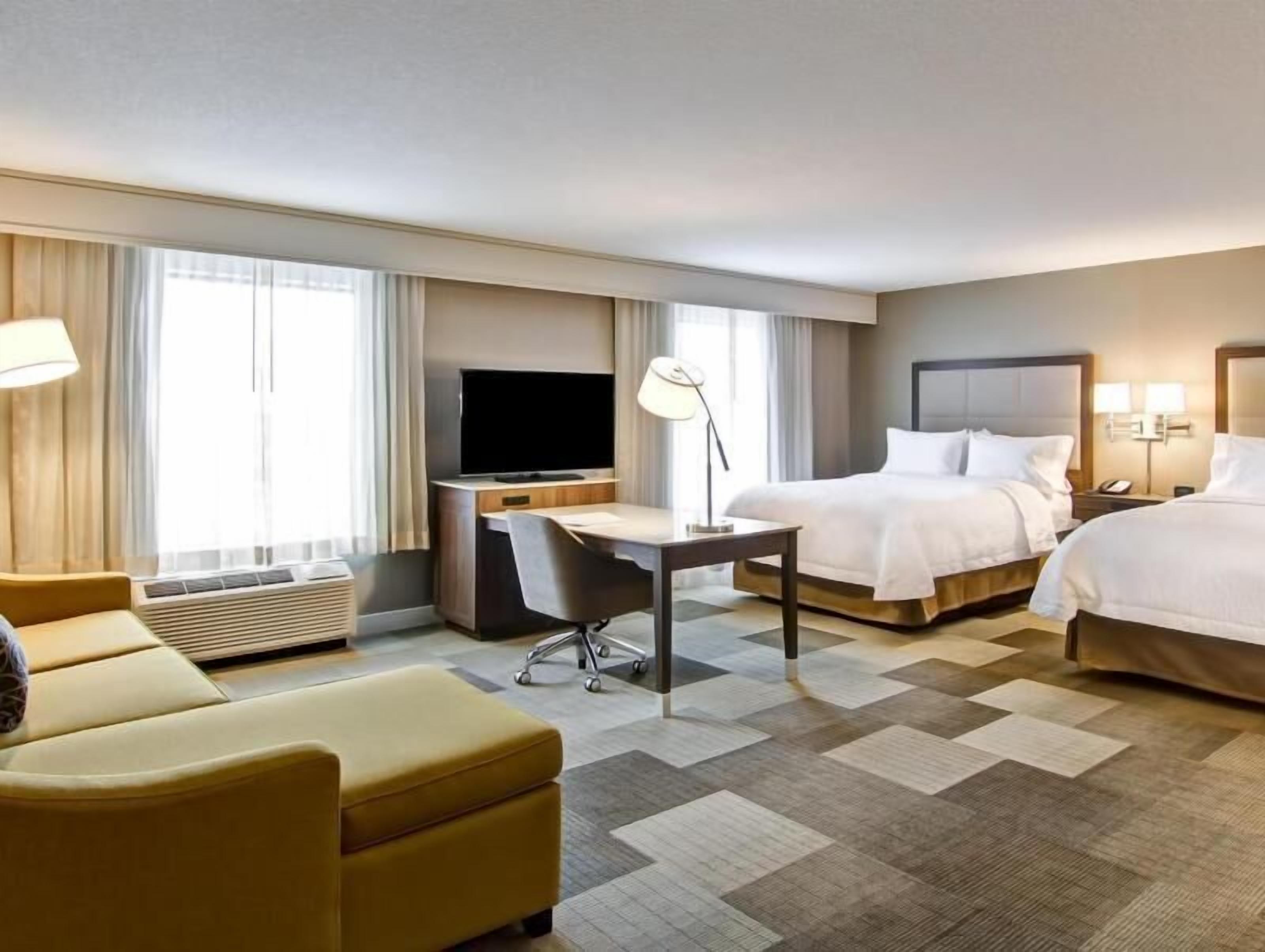 Camas con pillow-top, cortinas blackout y tabla de planchar con plancha 