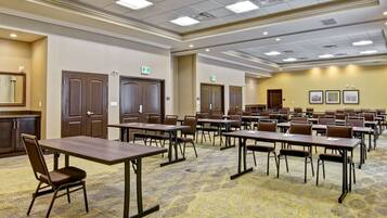 A conference room with multiple tables and chairs, equipped with nameplates and a carpeted floor.
