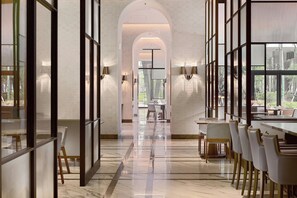 A modern interior with a long corridor, glass partitions, and a dining area with tables and chairs. - Taipei Marriott Hotel (Taipei)