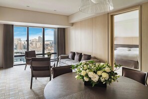 A modern hotel room with a large window, a dining table with chairs, a sofa, and a bed. - Taipei Marriott Hotel (Taipei)