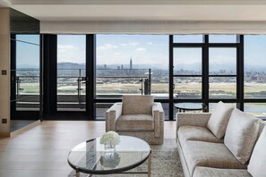 A modern living room with a large window, a sofa, a chair, and a glass coffee table. - Taipei Marriott Hotel (Taipei)