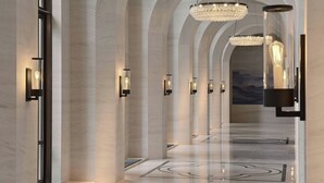 A modern hotel lobby with arched ceilings, chandeliers, and wall-mounted lighting. - Taipei Marriott Hotel (Taipei)
