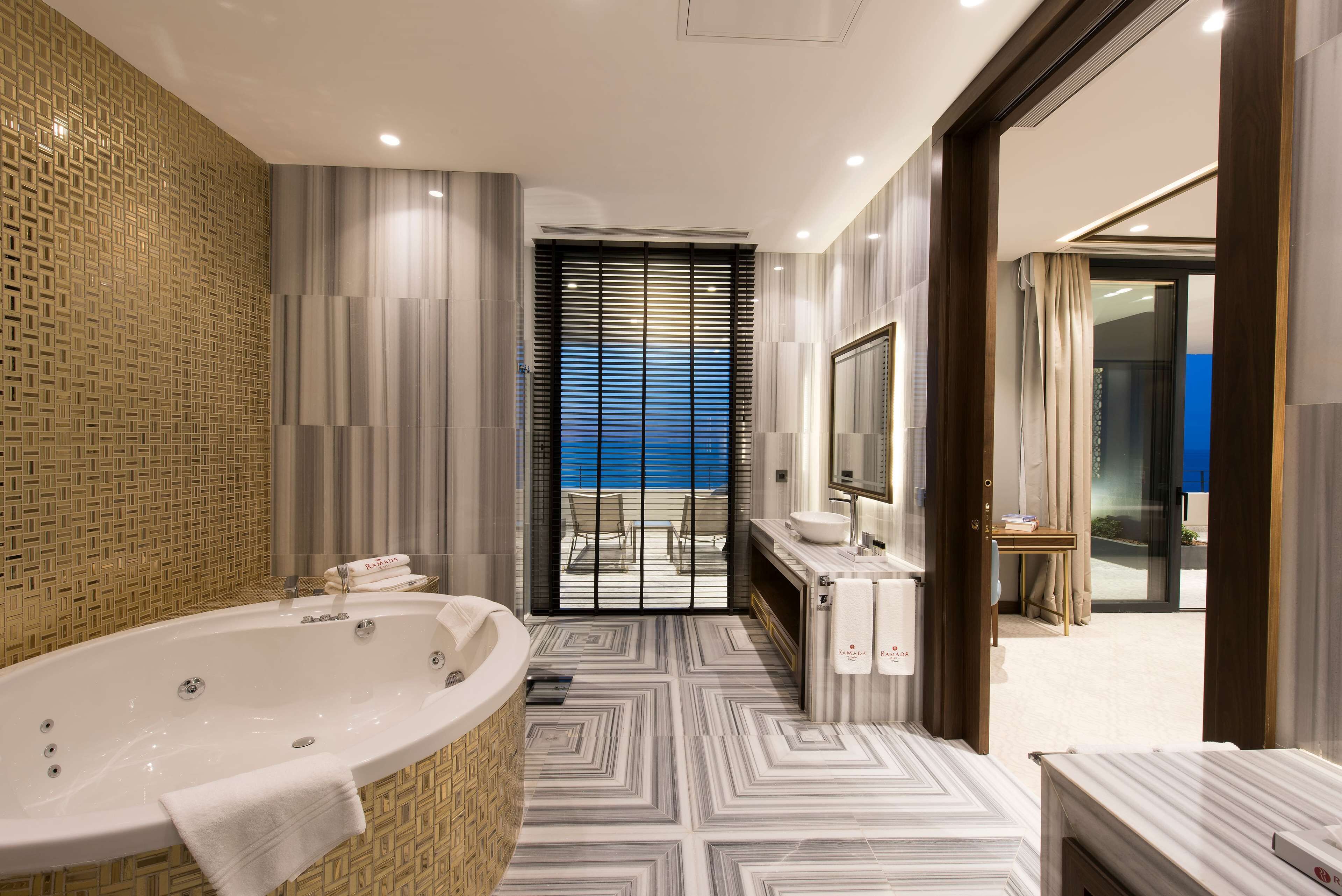 A modern bathroom with a large bathtub, a shower, and a vanity with a mirror.