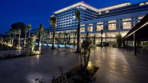 A modern hotel with multiple floors, a pool area, and outdoor seating. - Ramada Plaza by Wyndham Trabzon (Trabzon)