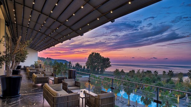 A rooftop lounge with outdoor seating, a pool, and a view of the sunset over the ocean. - Ramada Plaza by Wyndham Trabzon (Trabzon)