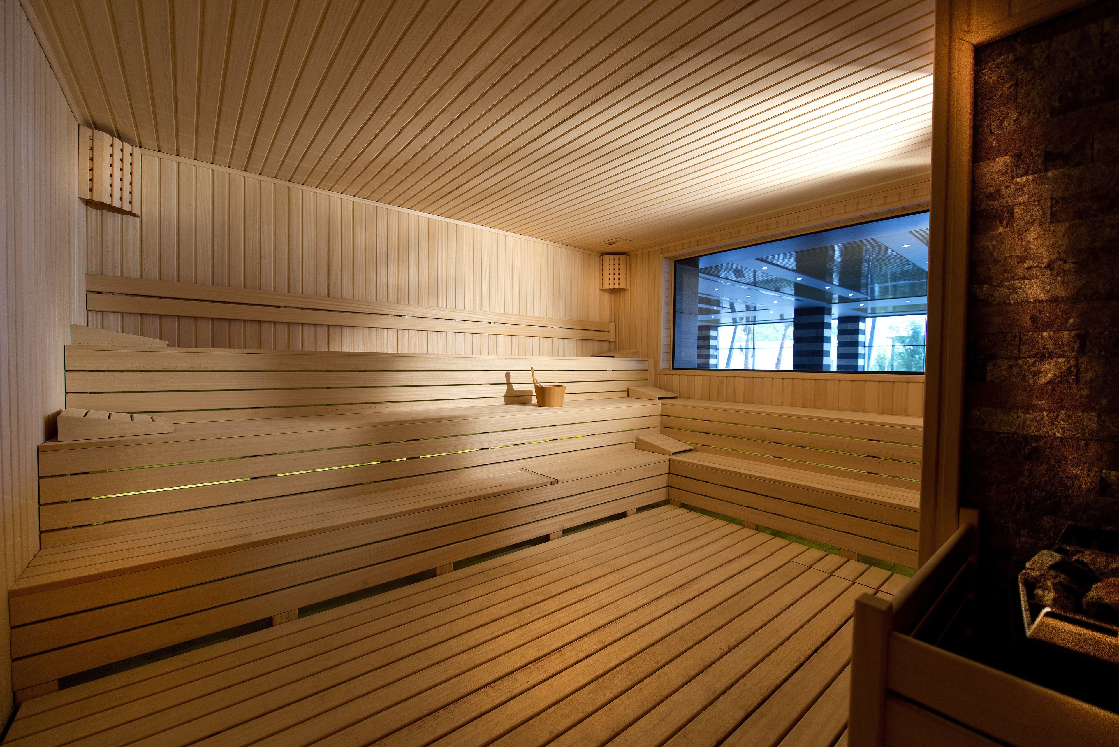 A sauna with wooden benches and a large window.