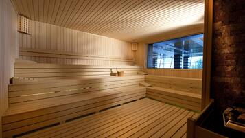 A sauna with wooden benches and a large window.