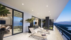 A modern balcony with seating, a dining area, and a view of the cityscape. - Ramada Plaza by Wyndham Trabzon (Trabzon)