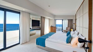 A modern hotel room with a large bed, a TV, a desk, and a view of the ocean. - Ramada Plaza by Wyndham Trabzon (Trabzon)
