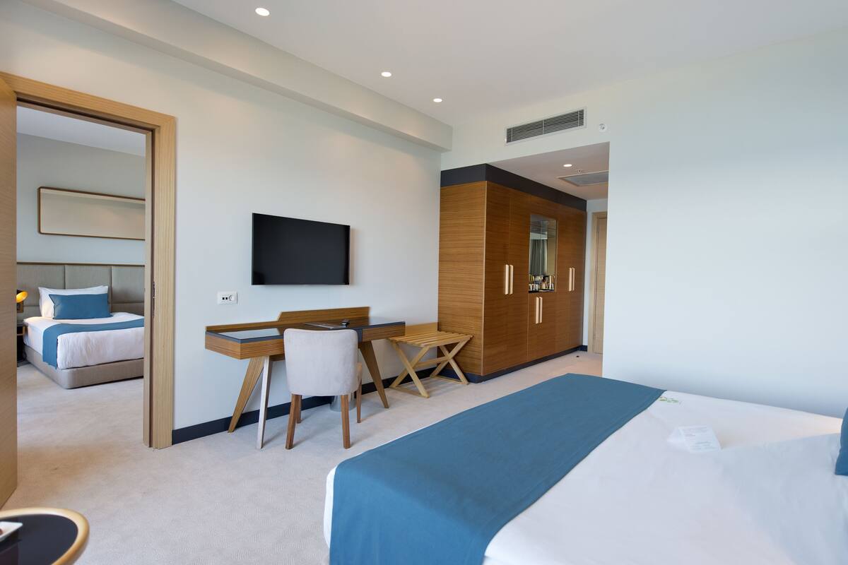 Une chambre d’hôtel moderne équipée d’un lit, d’un bureau, d’une chaise et d’une armoire.