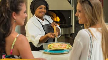 A pizza being prepared in a commercial kitchen with a wood-fired oven.