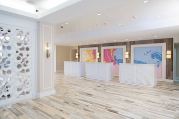 Welcome to our hotel lobby, featuring a spacious open area with polished floors, decorative partitions, and modern reception desks. at Warwick Paradise Island- All Inclusive- Adults Only