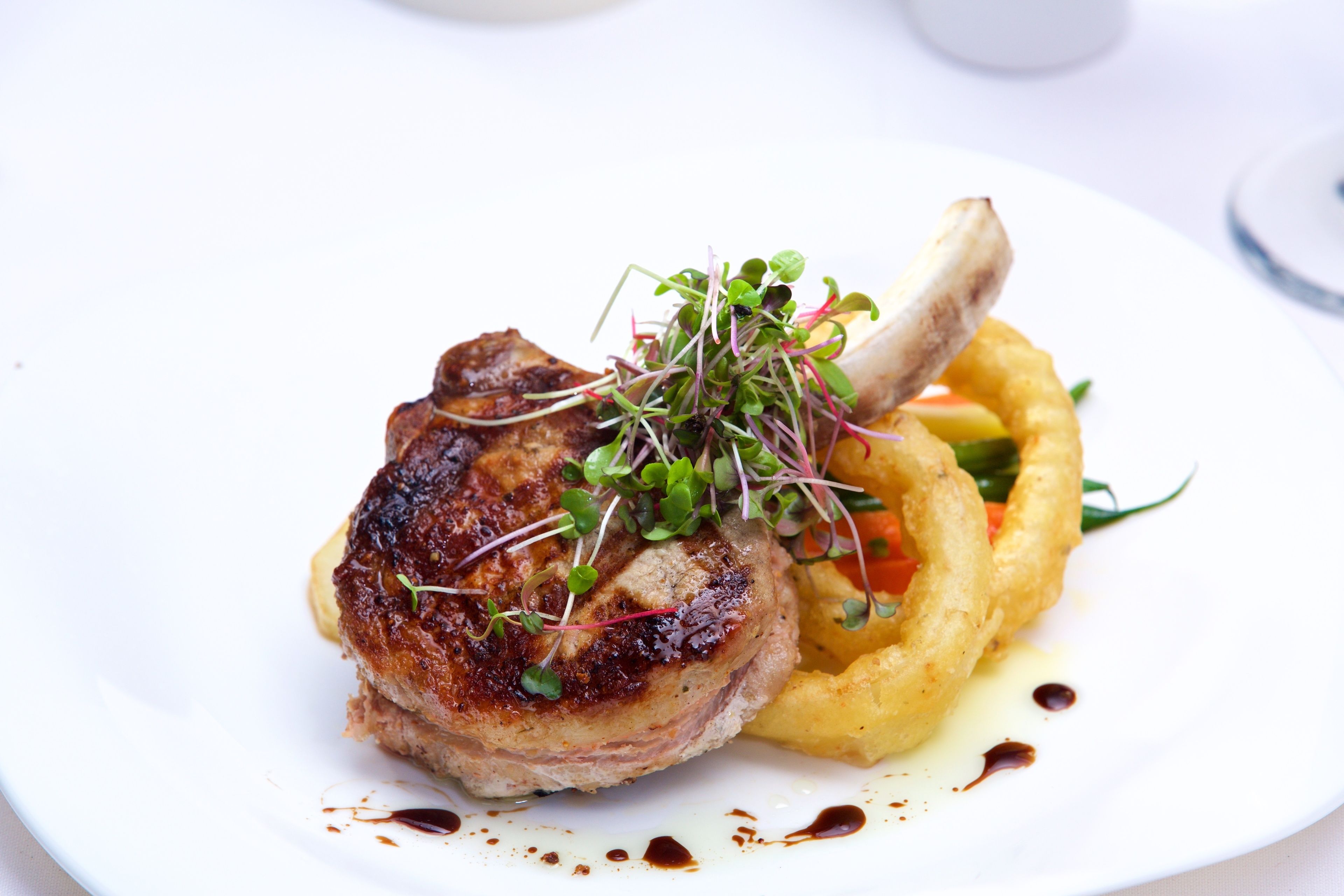 Une assiette comprenant une viande grillée, des frites et un accompagnement.
