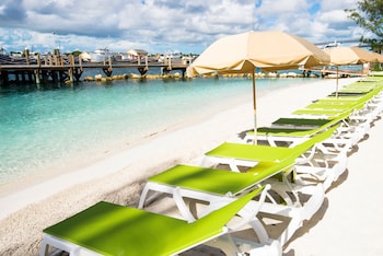 Relax in comfort by the ocean, surrounded by lounge chairs and umbrellas. at Warwick Paradise Island- All Inclusive- Adults Only