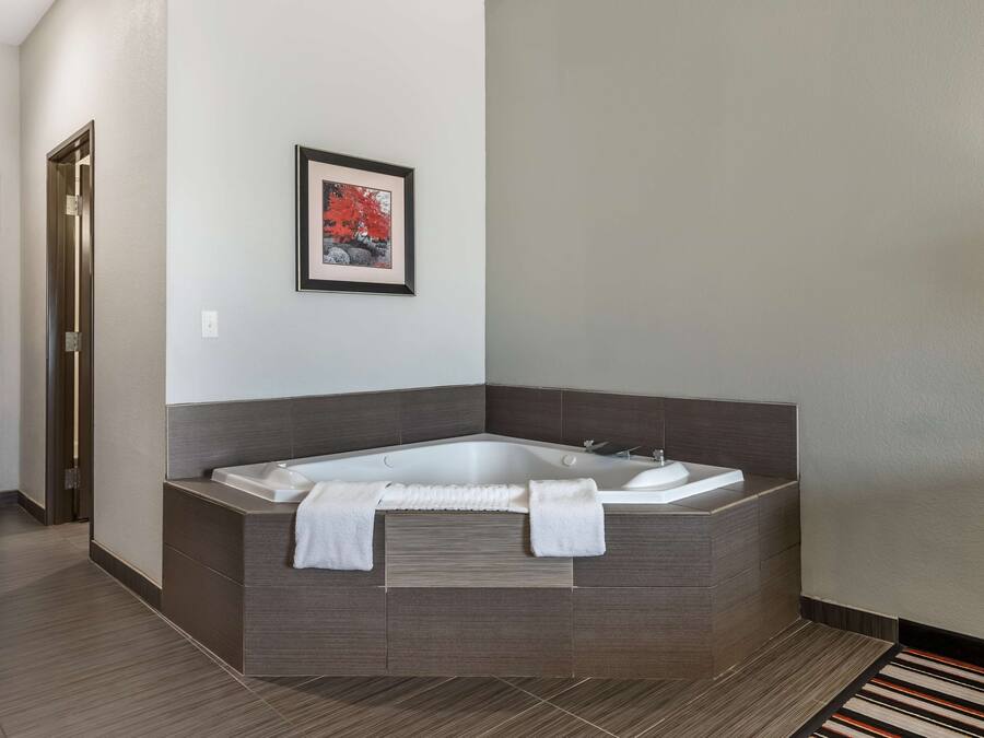 A modern bathroom with a freestanding bathtub, a framed picture on the wall, and a striped rug on the floor.