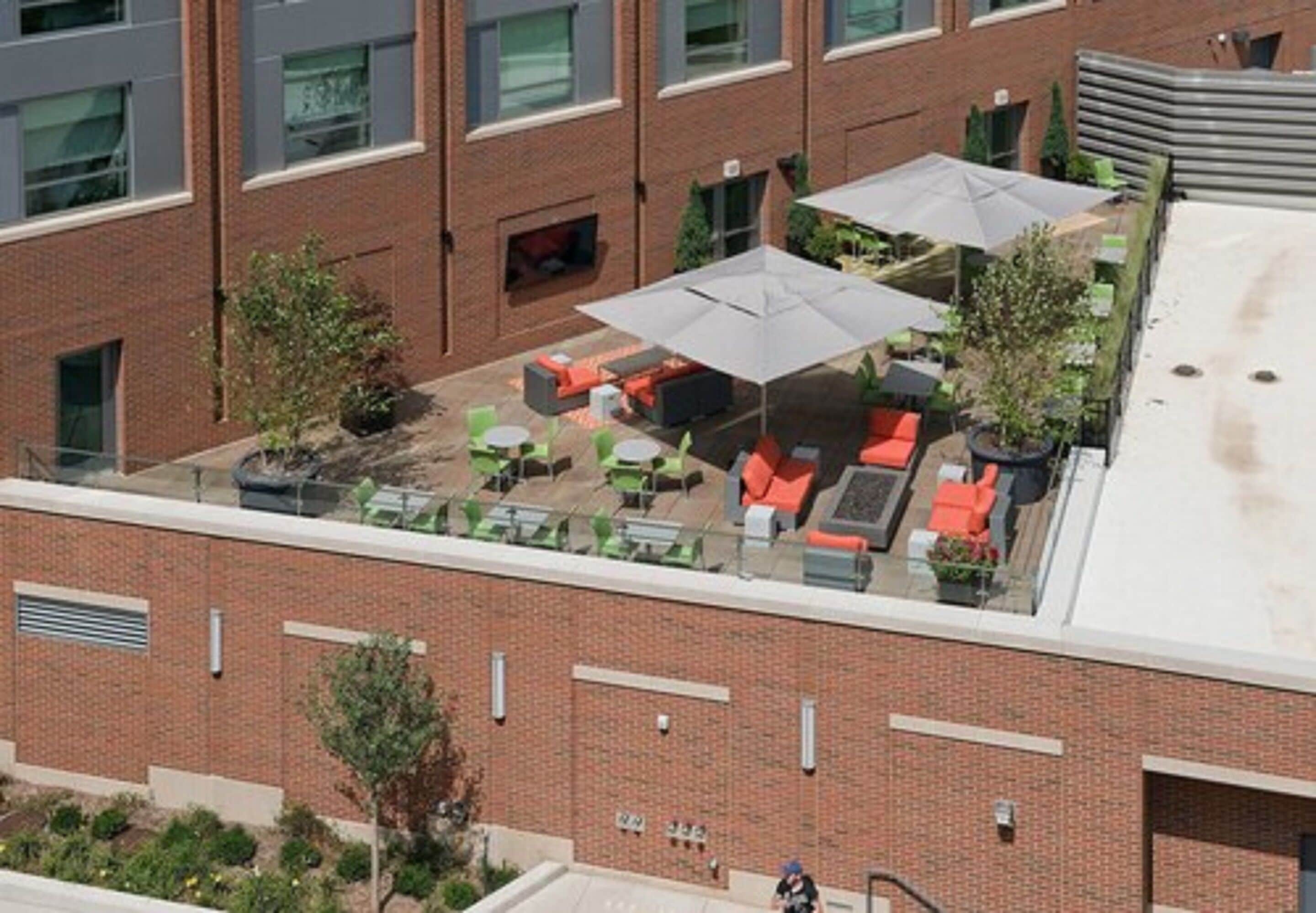 A rooftop patio with outdoor seating and umbrellas.