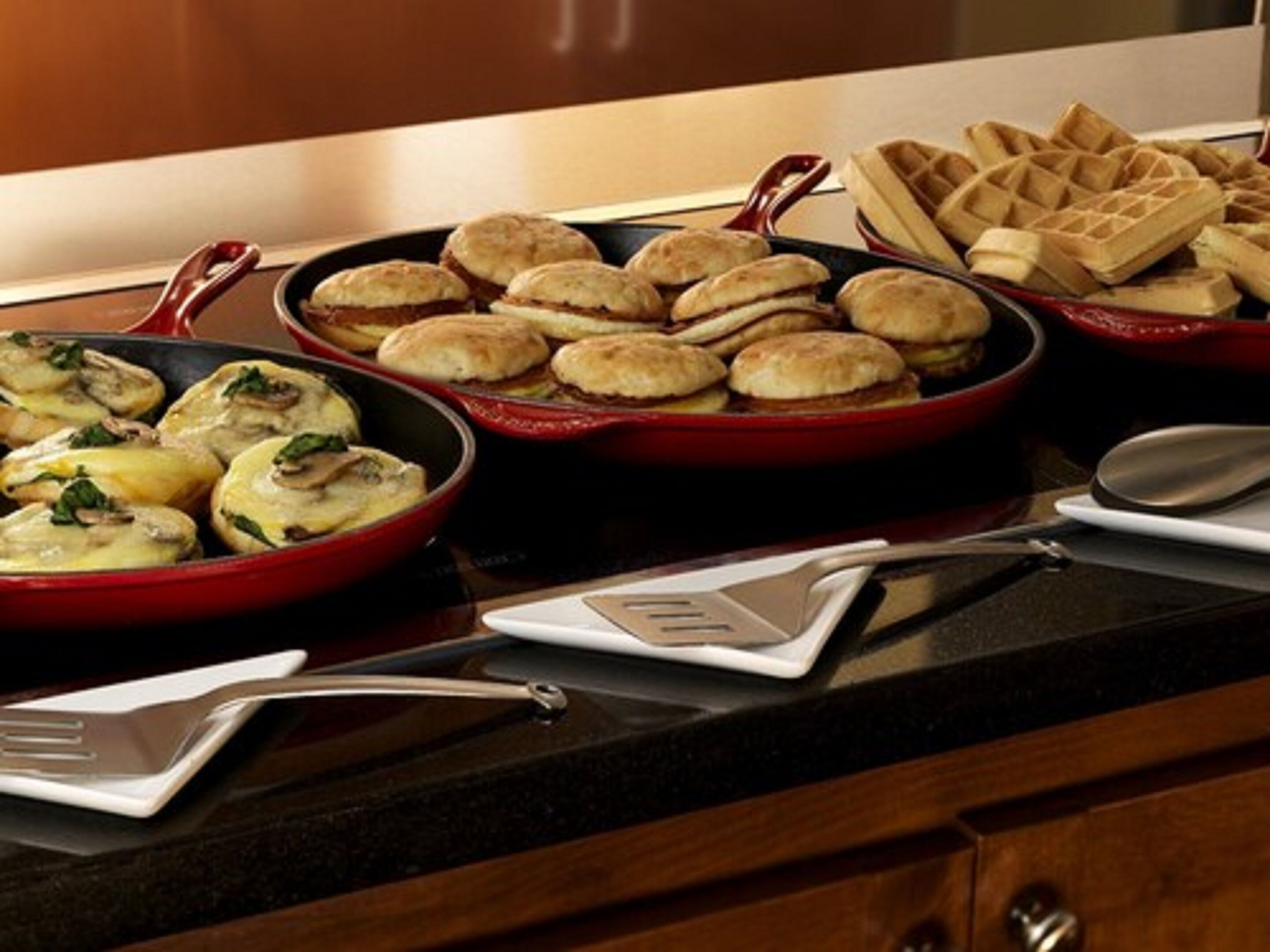 Een buffet met diverse gerechten, waaronder gebak en een ovenschotel.