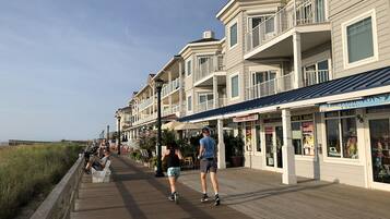Un paseo marítimo con edificios a un lado y una zona ajardinada al otro.