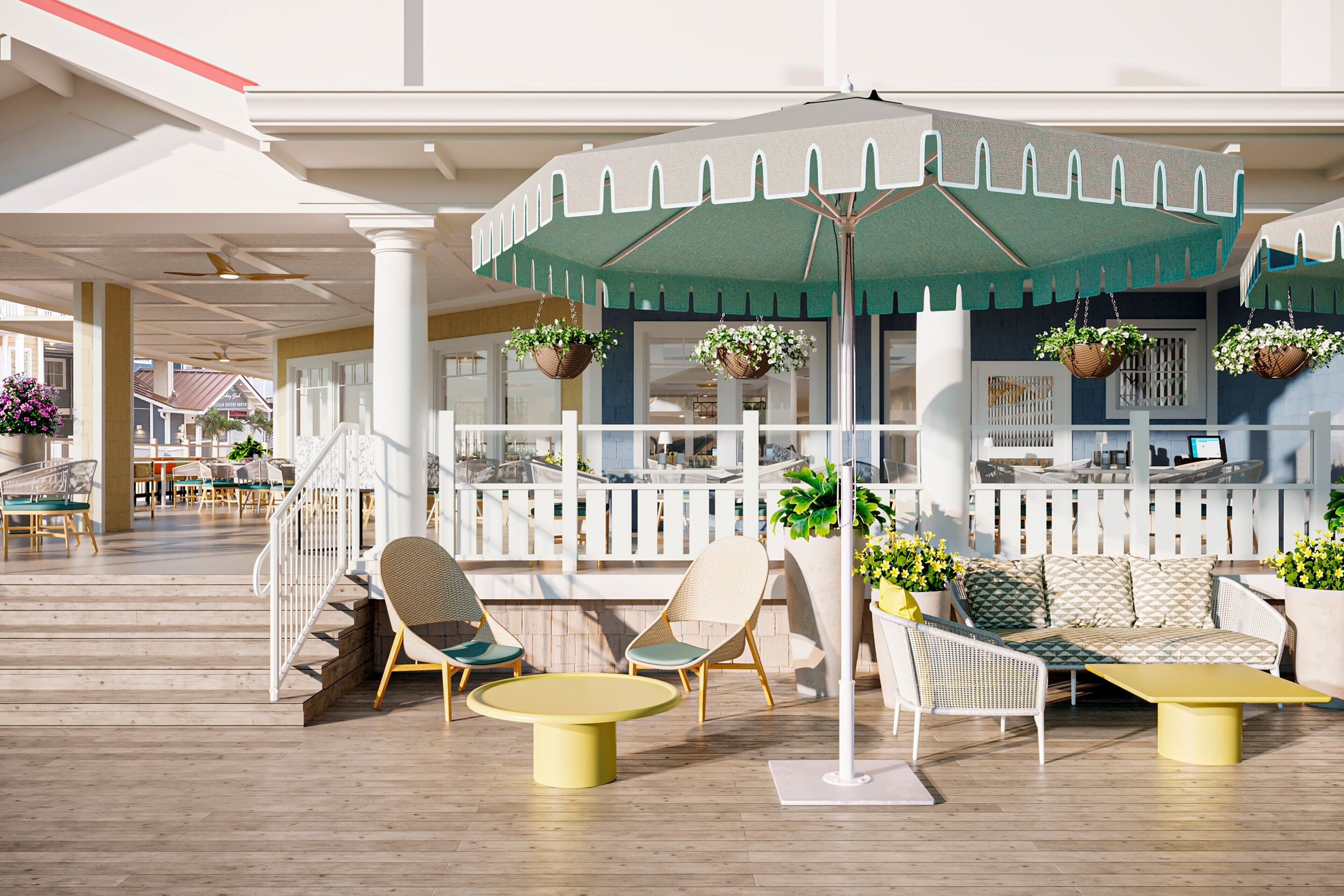 Un espace extérieur ensoleillé, aménagé avec des chaises en osier, une table jaune et un parasol vert.