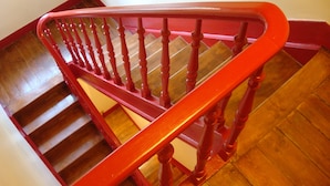 A wooden staircase with a red handrail and wooden steps.