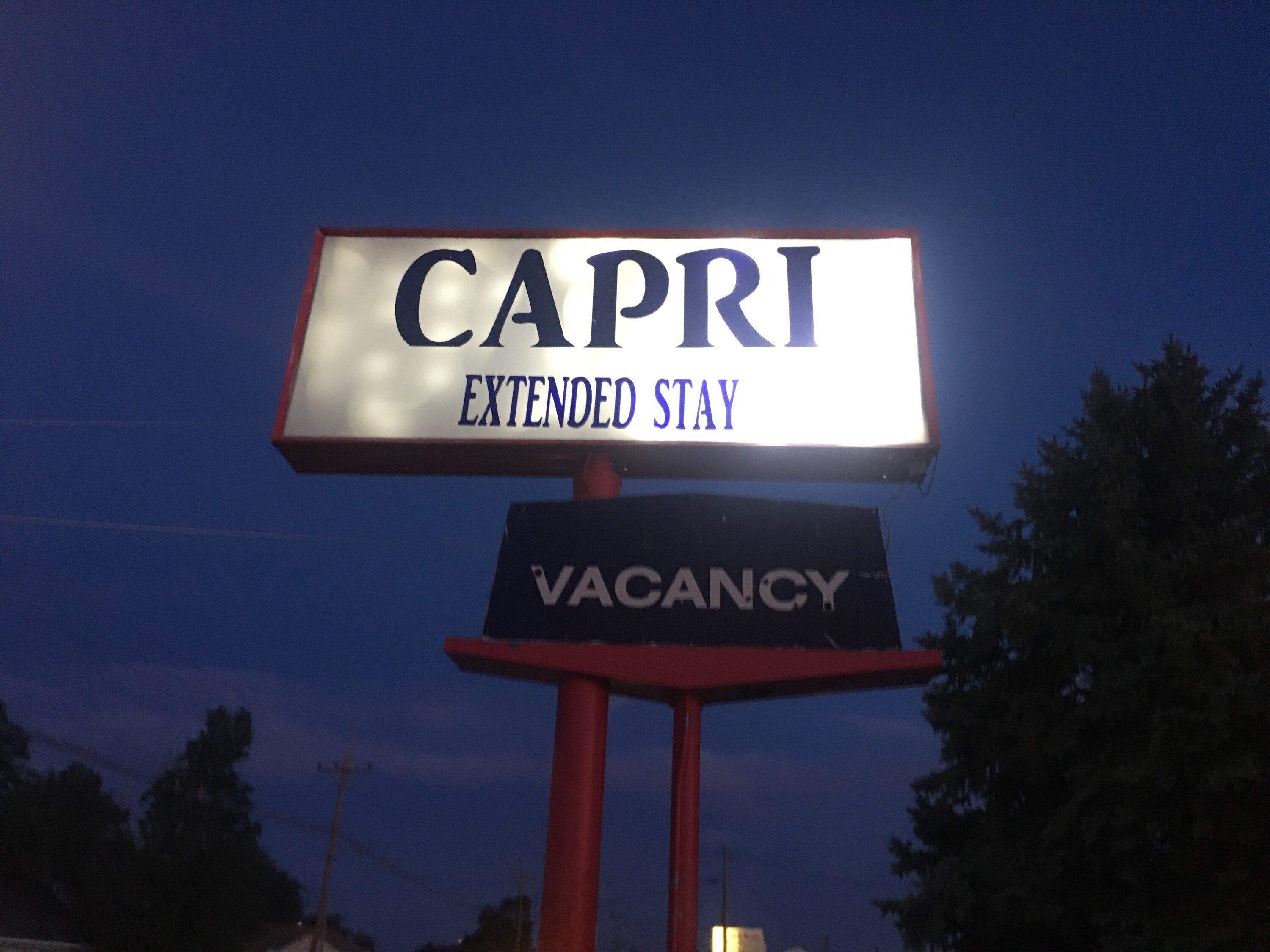 Señal de hotel que indica 'CAPRI' y 'ESTANCÍA PROLONGADA', mostrando el nombre y tipo de alojamiento.