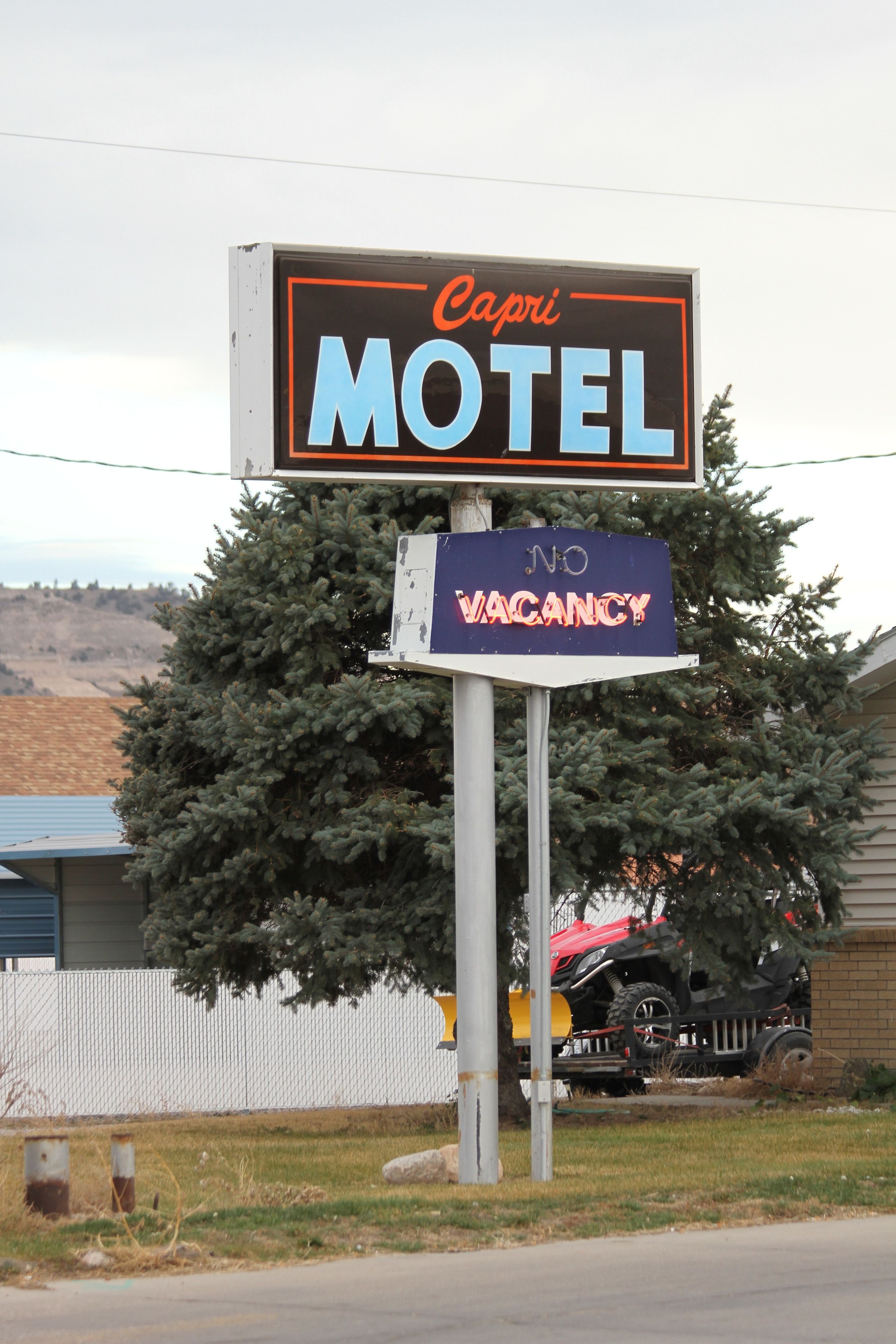 A motel sign with "Capri Motel" and "NO VACANCY" displayed.