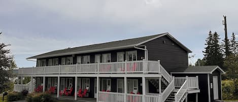 Ein zweigeschossiges Gebäude mit Balkon und überdachter Veranda.