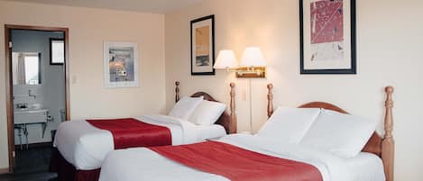 Une chambre d’hôtel avec deux lits, une salle de bain et un couloir.