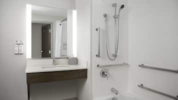 A modern bathroom with a white sink, mirror, and shower.