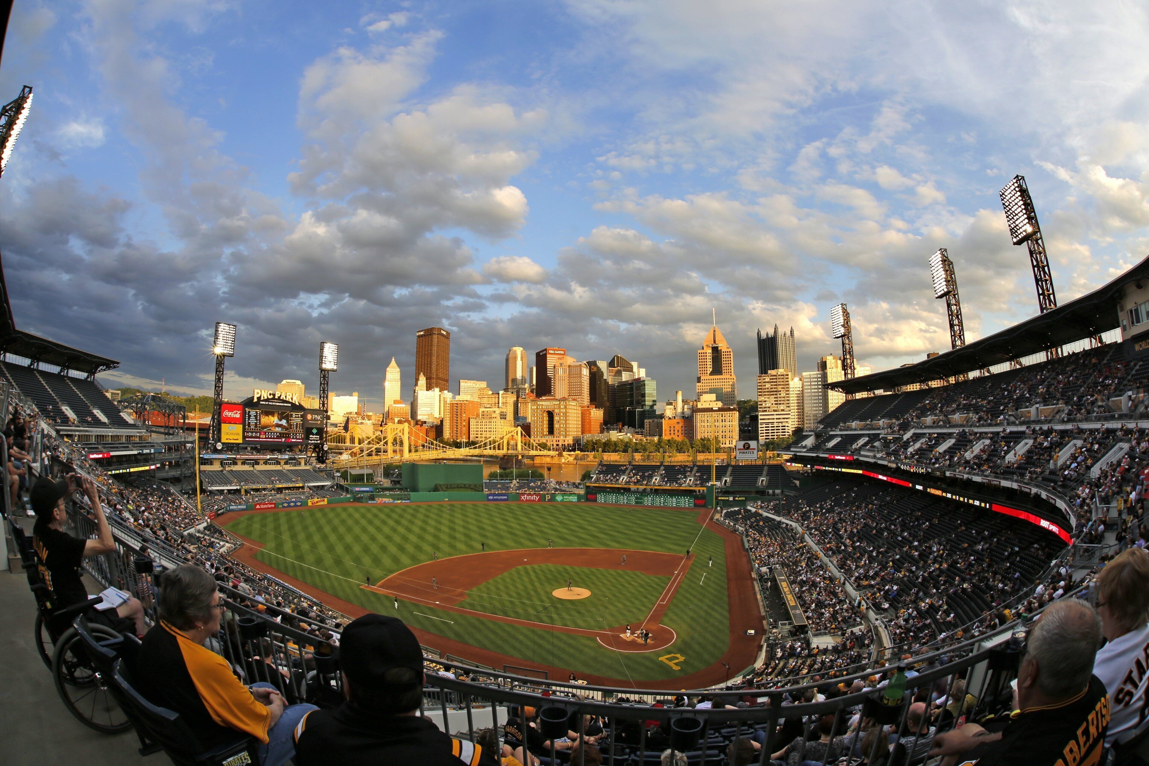 A baseball stadium with a view of the city skyline in the background.