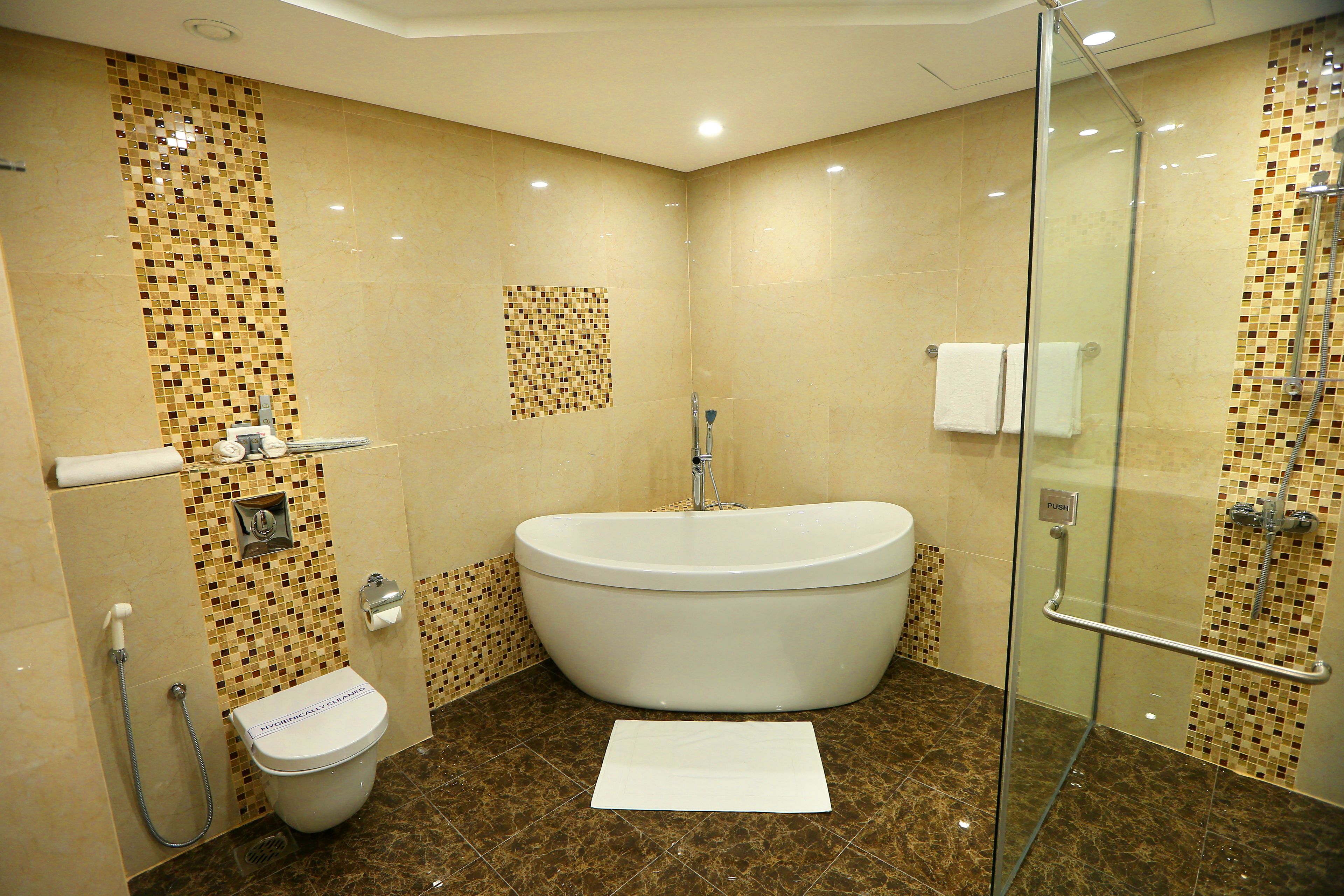 A bathroom with a freestanding bathtub, a glass-enclosed shower, and a toilet.
