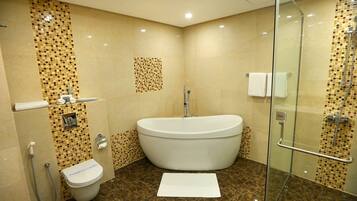 A bathroom with a freestanding bathtub, a glass-enclosed shower, and a toilet.