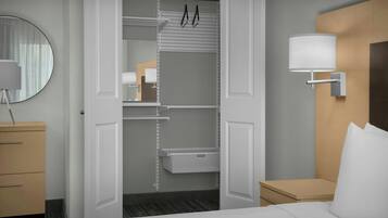 A hotel room with a bed, a bedside table, a lamp, a wardrobe, and a mirror.