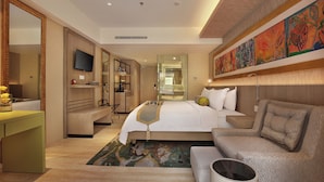 A modern hotel room with a large bed, a sofa, a TV, and a bathroom. - SenS Hotel and Spa Conference Ubud Town Centre (Ubud)