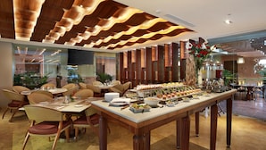 A buffet setup with various food items and a large floral centerpiece. - SenS Hotel and Spa Conference Ubud Town Centre (Ubud)
