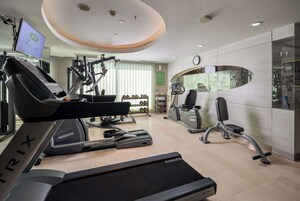 Una palestra moderna con tapis roulant, macchinari ellittici e attrezzature per il sollevamento pesi.